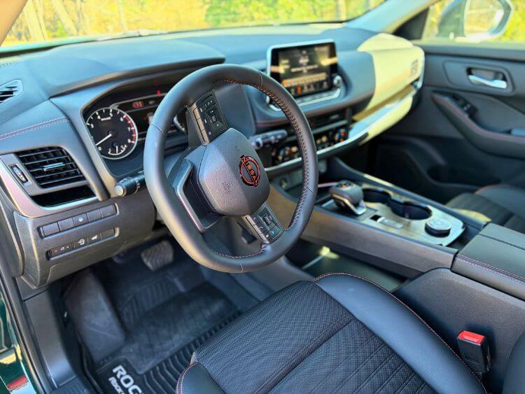Inside the 2026 Nissan Rogue Rock Creek cabin with lava-red stitching