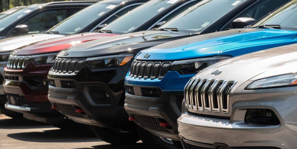 Editorial Credit Sharkshock / Shutterstock.com. Unsold Jeep Cherokees on a car dealer lot in Cary, NC, 2022.