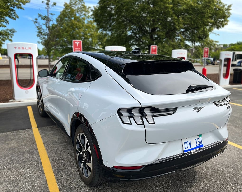 A Mustang Mach-E at at Tesla charging station. Photo credit: Ford.