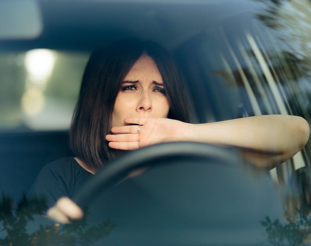 A drowsy driver yawning at the wheel. Photo Credit: Nicoleta Ionescu/Shutterstock.com.